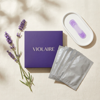 Violaire purple whitening kit flat lay — violet box, foil sachets, purple strip on ceramic tray with lavender