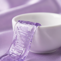 Macro detail of a translucent purple Violaire whitening strip on a ceramic dish